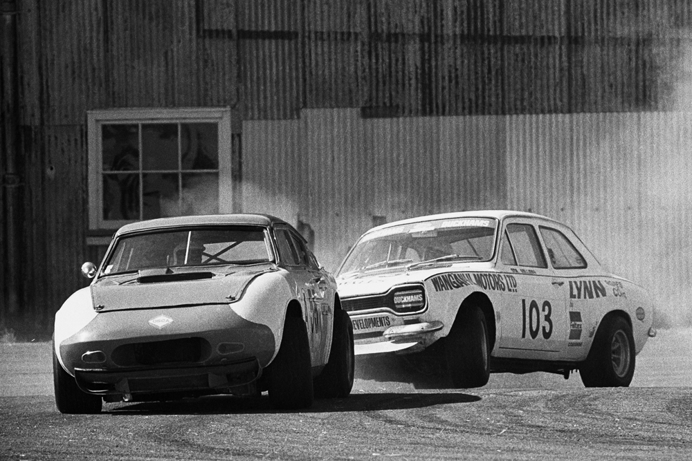 Smoke and drama at Wigram 1972. Alec Dickies x Neil Doyle Anglia Corvette leads Don Hallidays wheel hopping Escort out of the loop corner. IMAGE/terry marshall