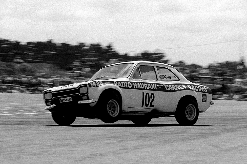 Wigram 1972. Jim Richards at his brilliant best 3 wheeling the Carney Escort off Hanger bend and around towards the Control Tower bend. IMAGE/terry marshall