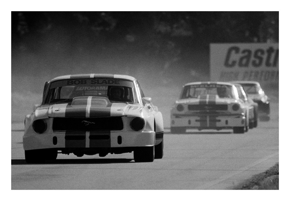Ruapuna, mid 70’s. Bob Slade leads Rod McElrea in matching white and blue Mustangs during one of their many OSCA battles. IMAGE/terry marshall